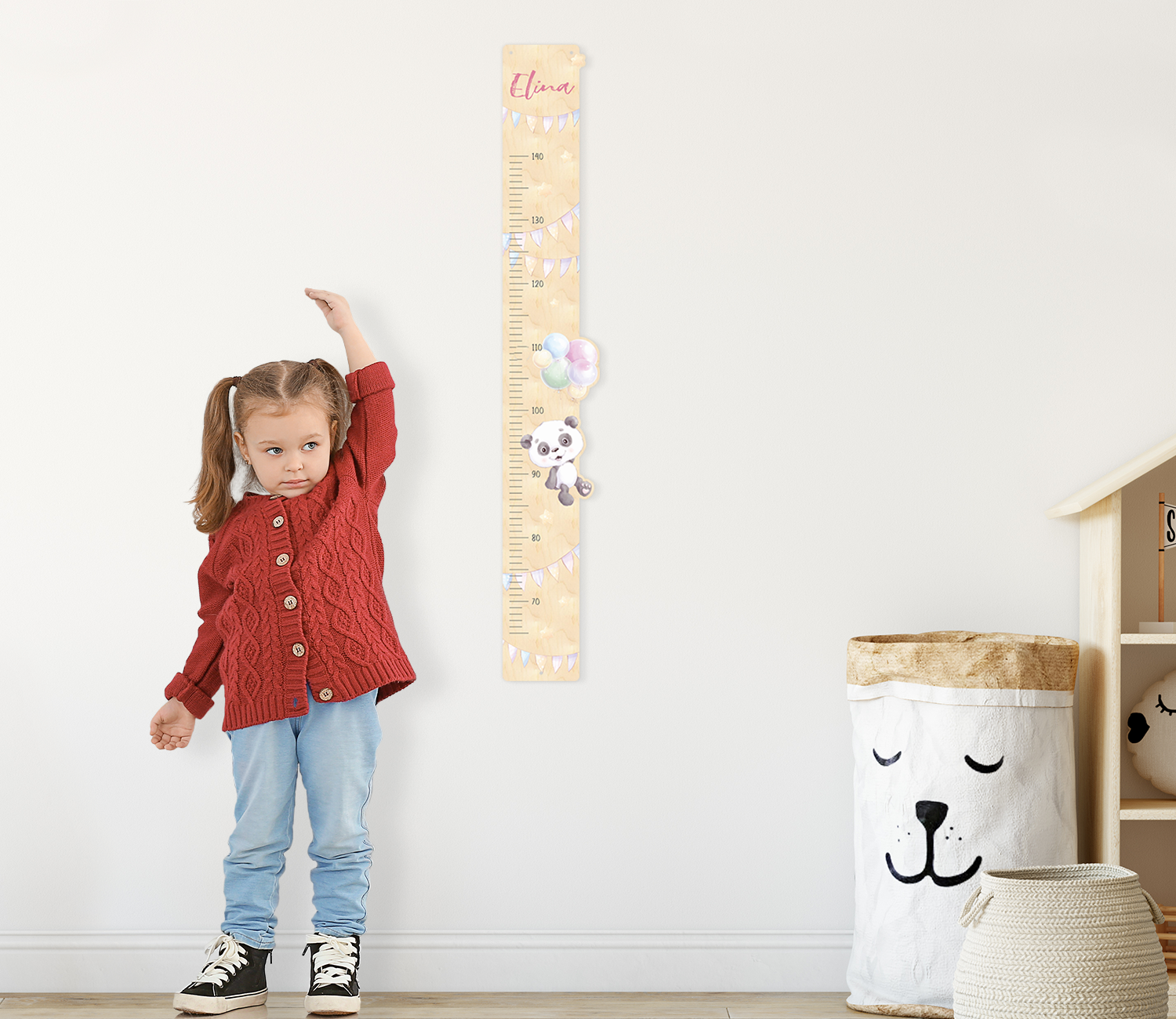 Holz-Messlatte mit Panda neben Mädchen im Kinderzimmer