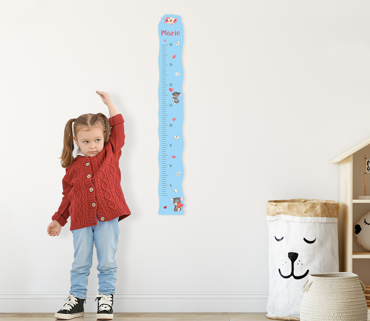 Blaue Messlatte mit Mäusen neben Mädchen im Kinderzimmer