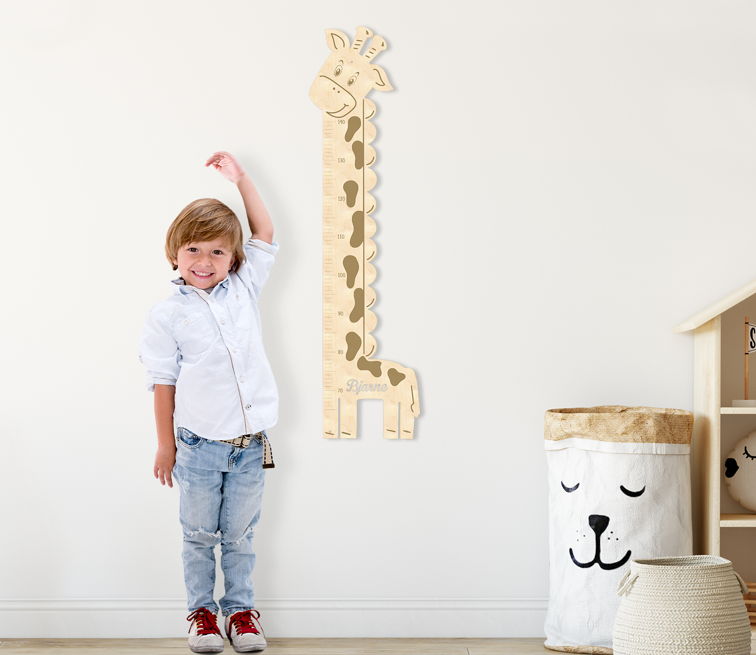 Messlatte hängt im Kinderzimmer neben Junge