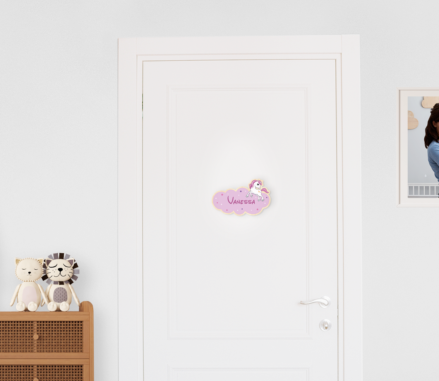 Türschild aus Holz bedruckt mit einer Wolke, Sternen, einem Einhrorn und personalisiertem Namen, montiert an einer Kinderzimmertür.